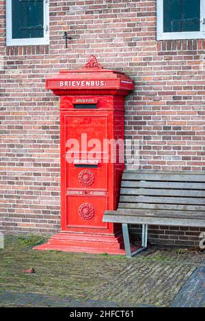 Old red colored Dutch mailbox, nowadays disappeared from the streets. Stock Photo