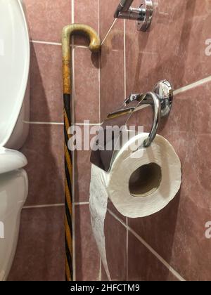 toilet paper, incorrectly hung toilet paper roll with selective focus in bathroom of an elderly person's home. bathroom interior of old people with no Stock Photo