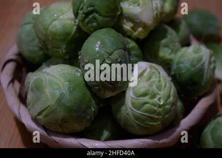 Close-up of brussels sprouts inside wicker basket on rustic wooden table Stock Photo