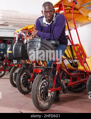 Nice driver of pedicab offering touristic tour Stock Photo