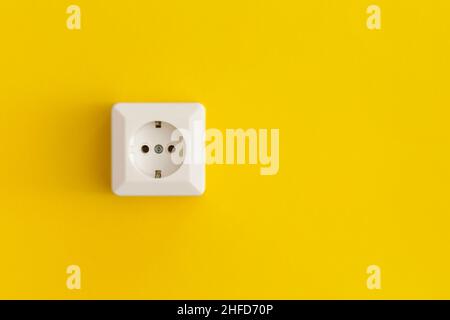 White plastic power socket on a yellow background Stock Photo