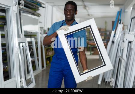 Portrait of man worker who is standing with window frame Stock Photo
