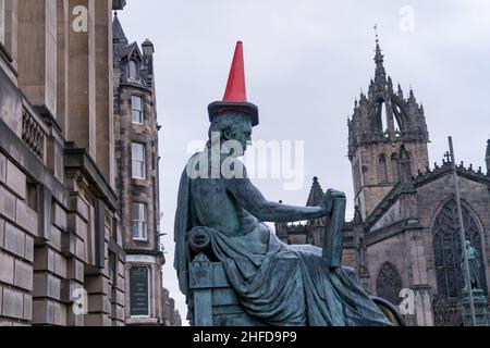 The statue of Scottish philosopher David Hume on Edinburgh's Royal Mile, with a red traffic cone on its head Stock Photo