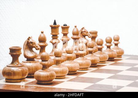 White chess pieces on the board on white background. Start position of chess pieces. Stock Photo