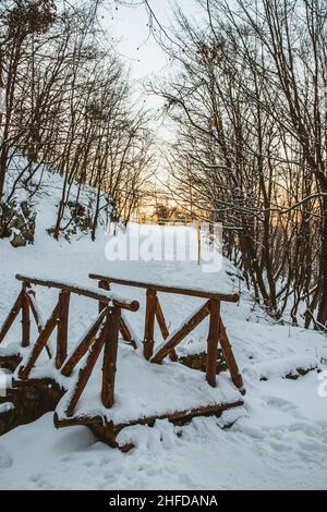 Wooden bridge in Vitosha mountain park in Bulgaria. Bridge is covered with snow. Winter time. Beautiful white snow. Stock Photo
