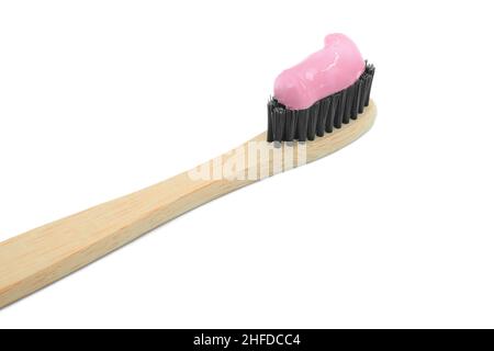 Closeup of bamboo toothbrush with blue toothpaste isolated on white background. Personal oral hygiene concept. Pink female color. Stock Photo