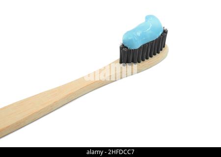 Closeup of bamboo toothbrush with blue toothpaste isolated on white background. Personal oral hygiene concept. Blue male color. Stock Photo
