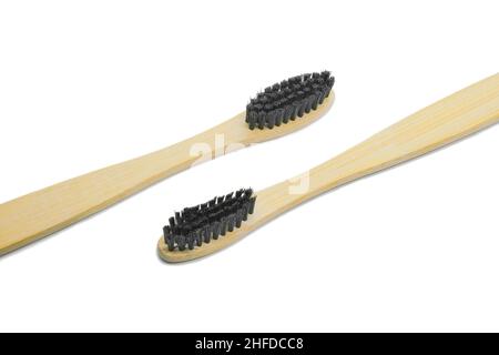 Two bamboo toothbrushes with black bristles isolated on white background. Personal oral hygiene concept. Stock Photo