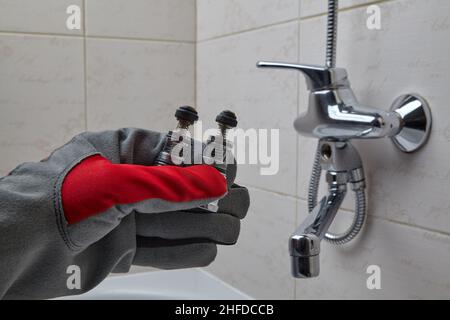 Plumber demonstrate a worn out and new shower valve switch Stock Photo