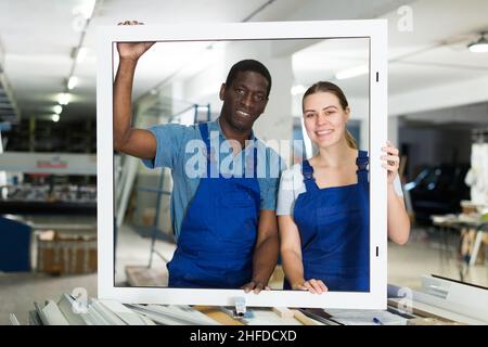Two masters are working with window frame Stock Photo