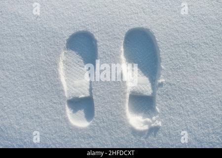 Top view on two footprints in powder snow. Winter season and snowfall concept. Stock Photo