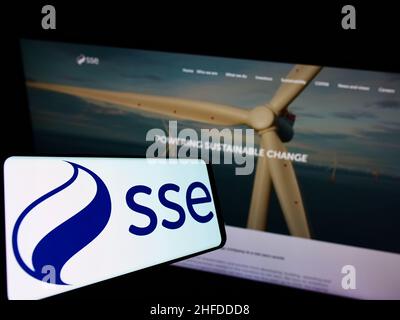 Mobile phone with logo of British energy company SSE plc on screen in front of business website. Focus on center of phone display. Stock Photo