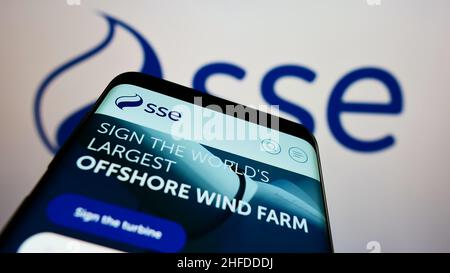 Smartphone with website of British energy company SSE plc on screen in front of business logo. Focus on top-left of phone display. Stock Photo