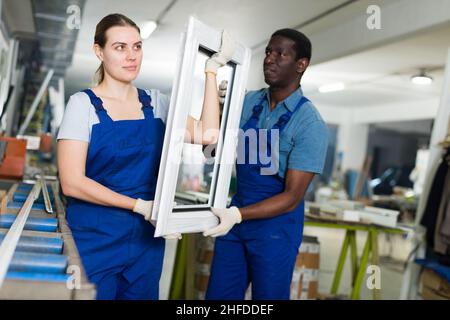 Two masters are working with window frame Stock Photo