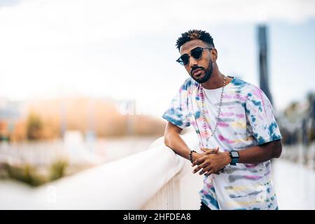 Portrait of a young Caribbean man leaning on the railing of a bridge Stock Photo