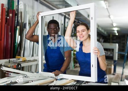 Two masters are working with window frame Stock Photo