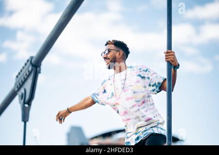 Smiling black man in sunglasses enjoying happy with arm outstretched enjoying the moment Stock Photo