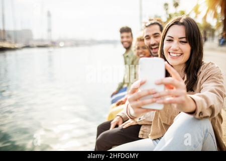 Multi ethnic group of best friends taking vertical selfie with smart phone Stock Photo