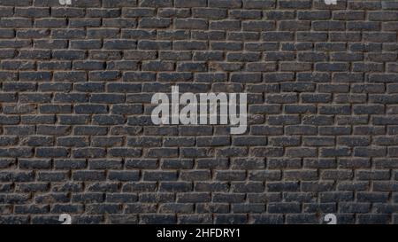 Horizontal part of dark brick wall background. Exterior wide old stone bricks texture for pattern. Home or office design backdrop Stock Photo