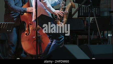Caucasian men at a concert playing jazz and blues on saxophone and contrabass Stock Photo