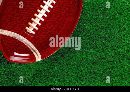 Background with american football plate on green grass. Top view. Stock Photo