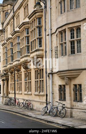 bicycles on sidewalk leaning against old stone college building Stock Photo