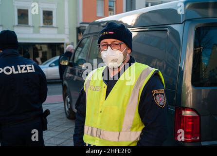 Amstetten, Austria - January 15 2022: Austrian Police Officer Wearing Covid-19 Surgical FFP2 Mask Controlling Protest against Mandatory Vaccination Stock Photo