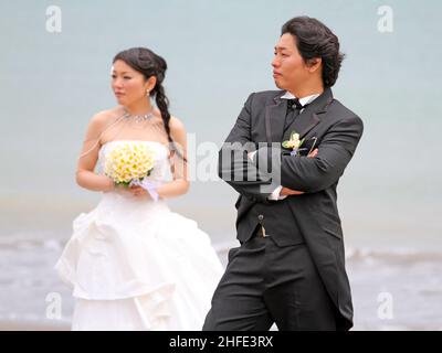 An Asian couple have pre-wedding photographs taken on Tuban Beach, Bali in Indonesia. Stock Photo