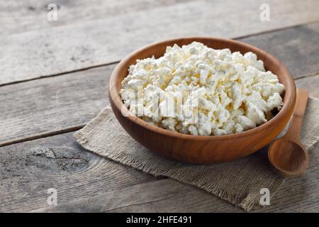 cottage cheese in brown wooden bowl with spoon Stock Photo