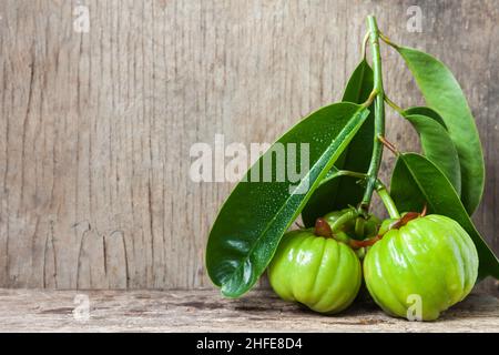 Still life garcinia atroviridis fresh fruit on old wood background. Thai herb and sour flavor lots of vitamin C. Water drops on leafs. Extract as a we Stock Photo