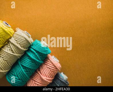 colorful reels of macrame cord threads or wool shot as copy space background or text background. studio shot. Stock Photo