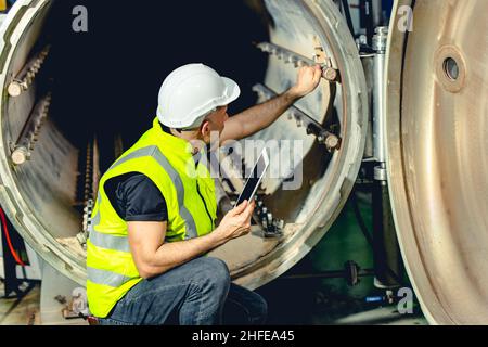 engineer work service checking and maintenance industry boiler in heavy factory Stock Photo