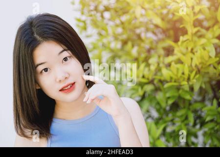 cute lovely portrait asian Thai teen smile with green nature copy space. Stock Photo