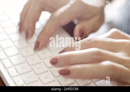 Close-up view woman hands typing on white keyboard Stock Photo