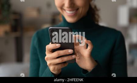 Close up young woman using cellphone at home. Stock Photo