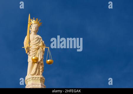 Lady Justice holding balance scales and sword, a 15th century medieval statue at the top of St Mark Basilica in Venice (with blue sky and copy space) Stock Photo