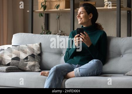 Relaxed young happy latin woman using cellphone gadget. Stock Photo