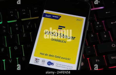 Viersen, Germany - January 9. 2022: Closeup of mobile phone screen with logo lettering of wiso steuer tax handling sofware on computer keyboard Stock Photo