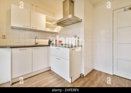 Delightful kitchen with a lovely kitchen set and a red ceramic cauldron on the gas stove Stock Photo
