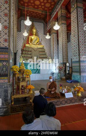 Bangkok, Thailand - January 2022: People making an offering at the Wat Arun Buddhist temple on January 16, 2022 in Bangkok, Thailand Stock Photo