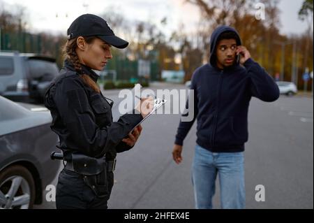 Upset man and police woman issuing fine Stock Photo