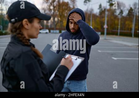 Upset man and police woman issuing fine Stock Photo