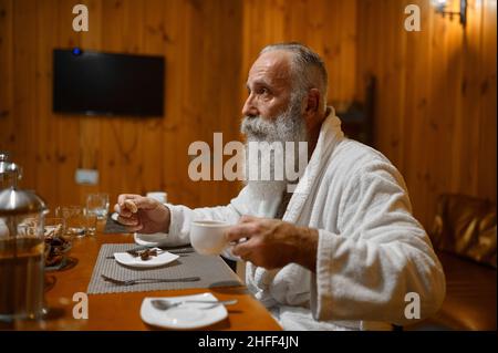 Senior man drinking tea rest in sauna Stock Photo
