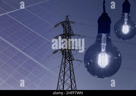 Electricity transmission tower silhouetted against blue sky at dusk Stock Photo