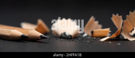 Close up photo of wooden pencil and pencil wastes on grey background. Concept of education and study. Stock Photo