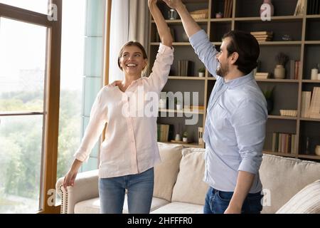 Young couple holding hands dancing to the favourite music Stock Photo