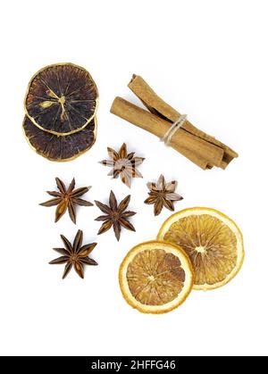 Star anise, cinnamon sticks and dry citrus fruits on a white background. Mulled wine seasoning top view. Fragrant dry spices for making drinks. Stock Photo