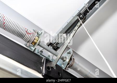 Springs tensioning the home garage door mechanism, visible disconnection of the electric drive and and spring protection. Stock Photo