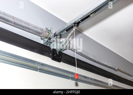 Springs tensioning the home garage door mechanism, visible disconnection of the electric drive and and spring protection. Stock Photo