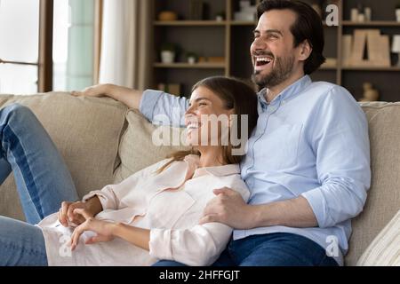 Couple relaxing on sofa laughing spend carefree weekend at home Stock Photo